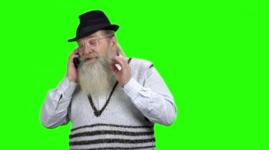 Şapkalı pozitif yaşlı adam telefonda konuşuyor.