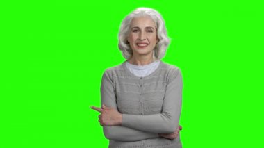 Gülümseyen kıdemli kadın boşluk kopyalamak için parmak ile işaret.