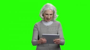 Dijital tablette oyun oynayan komik yaşlı kadın.