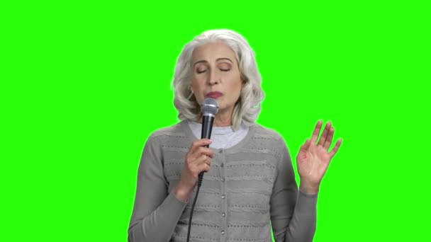 Κομψή ηλικιωμένη γυναίκα που τραγουδάει στο μικρόφωνο. — Αρχείο Βίντεο
