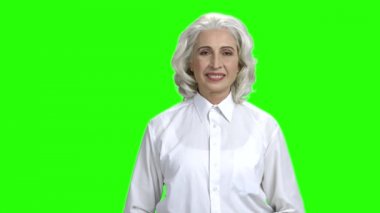 Yeşil ekranda başparmak veren Pretty üst düzey kadın.