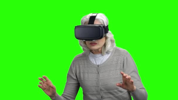 Старуха в наушниках виртуальной реальности. — стоковое видео