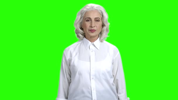 Femme âgée souriante sur fond vert . — Video
