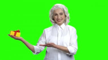 Hediye kutusu sunan güzel yaşlı kadın.