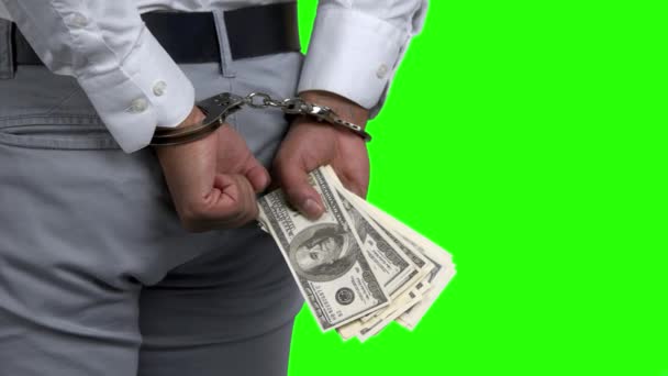Man in handcuffs holding money, back view.