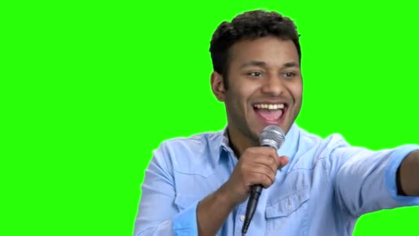 Energetischer Entertainer spricht auf grünem Bildschirm ins Mikrofon. — Stockvideo
