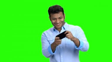 Mutlu asyalı adam telefonunda oyun oynuyor.