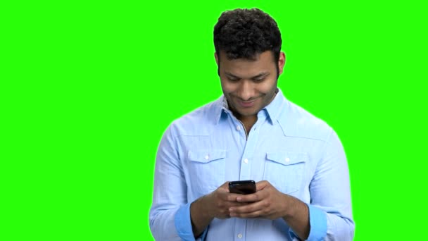Lächelnder Mann schreibt SMS auf sein Handy. — Stockvideo