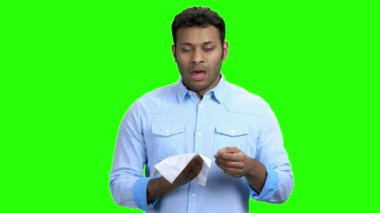 Genç adam hapşırmak üzere, yeşil ekran.