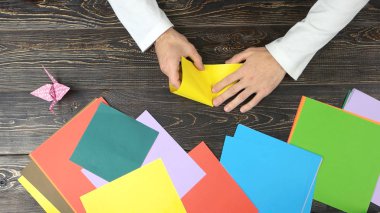 Erkek el ile sarı kağıt origami yapma.