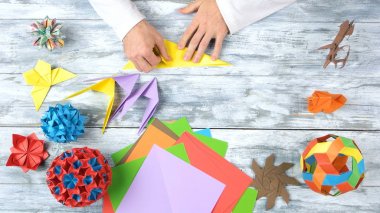Origami figürleri yaparken renkli kağıt katlama.