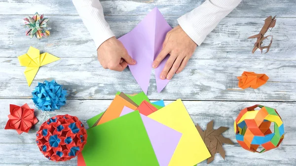 Maken van origami paarse driehoek. — Stockfoto