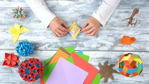Man handen maken mooie origami speelgoed. — Stockfoto