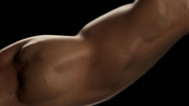 Close-up Mans biceps, donkere achtergrond. — Stockvideo