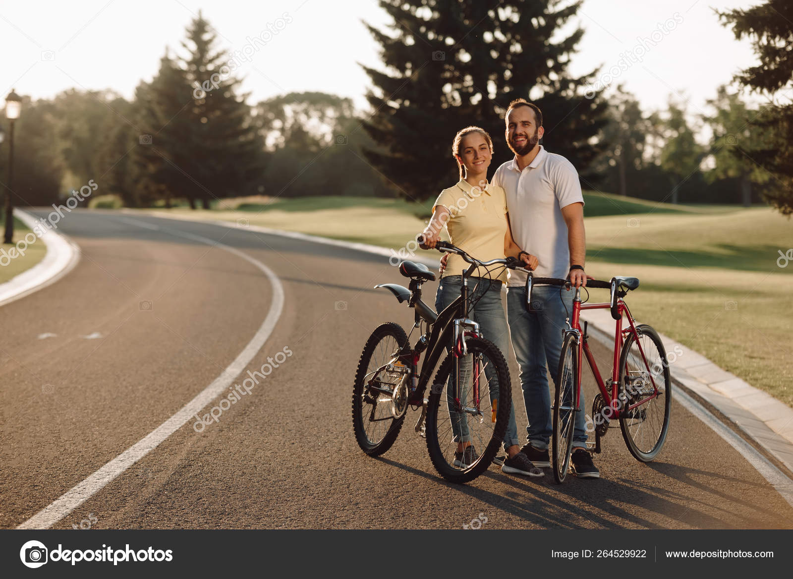 Pareja feliz posando con bicicletas en la carretera — Foto de