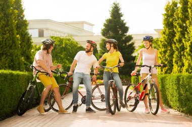 Dışarıda bisikletli neşeli insanlar grubu.