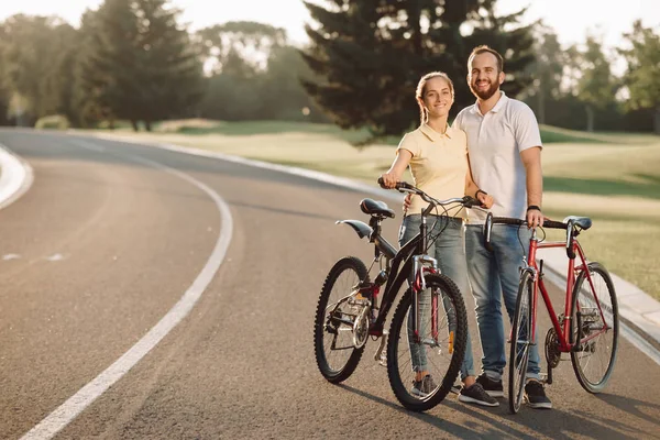 Par cyklister ler och tittar på kameran. — Stockfoto