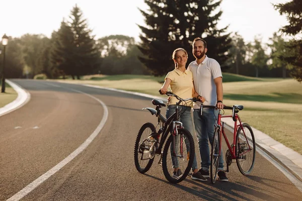 Lyckligt par poserar med cyklar på vägen. — Stockfoto