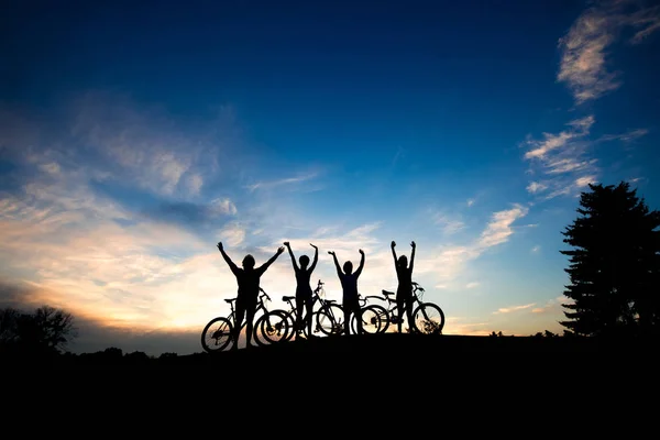 Силуети велосипедистів на фоні неба заходу сонця . — стокове фото