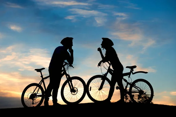 Couple de cycliste sur la colline au coucher du soleil . — Photo