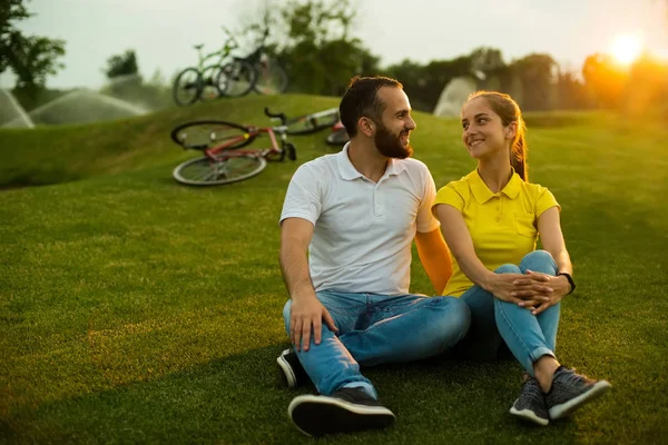 Пара влюбленных отдыхает на зеленой лужайке . — стоковое фото