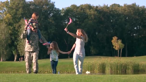 Family from USA waving backgrounds in the park, front view. — Stock Video