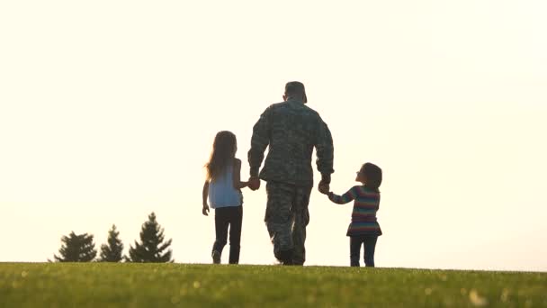 Soldat mit zwei Kindern, die Händchen haltend gehen. — Stockvideo
