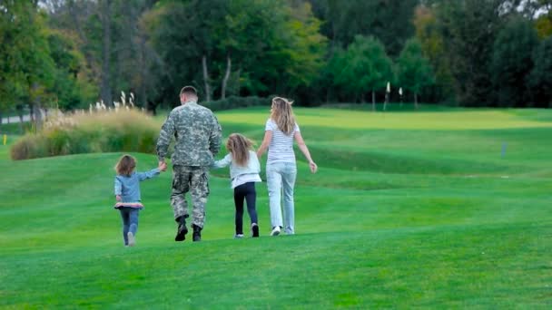 Familia feliz con el padre soldado caminando hacia adelante, vista trasera . — Vídeos de Stock