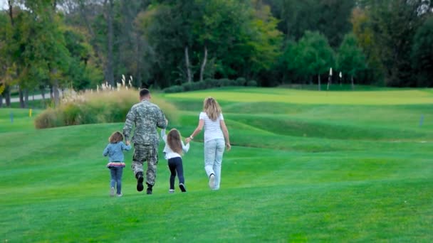 Αμερικανός στρατιώτης με την ευτυχισμένη οικογένεια του να διασκεδάζει στο λιβάδι του πάρκου. — Αρχείο Βίντεο