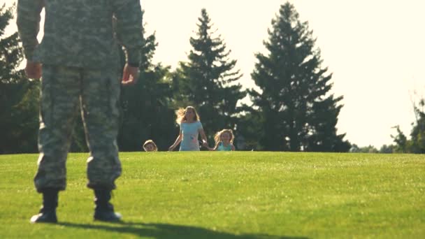 Vista posteriore è arrivato soldato in attesa della sua famiglia nel parco e abbracci . — Video Stock