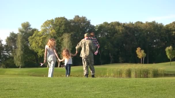Amerikansk veteran i camoubackgrounde med familje promenad bort. — Stockvideo