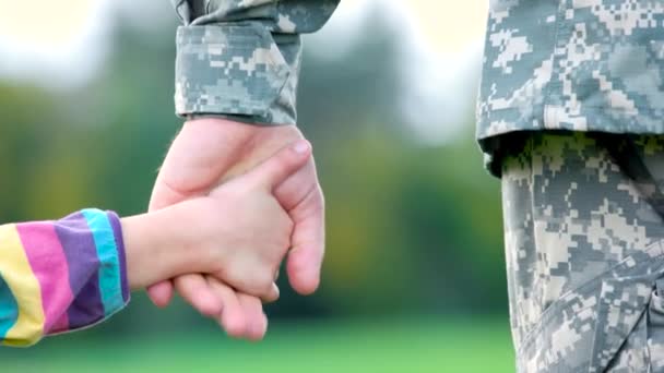 Soldier and little girl holding hands, close up. — Stock Video