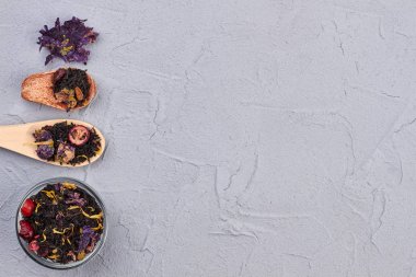 Gri arka planda kaşık ve kase siyah çay.