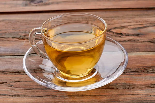 Kahverengi ahşap arka plan üzerinde yeşil çay Fincan.