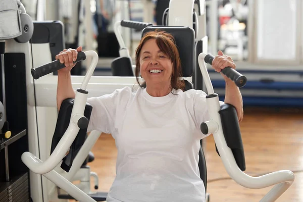 Smiling senior woman working out at gym. — Stock Photo, Image