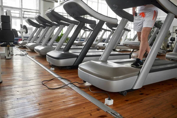 Hombre irreconocible en la cinta durante su entrenamiento en el gimnasio . — Foto de Stock