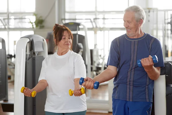 Caucasian senior people exercising at gym.