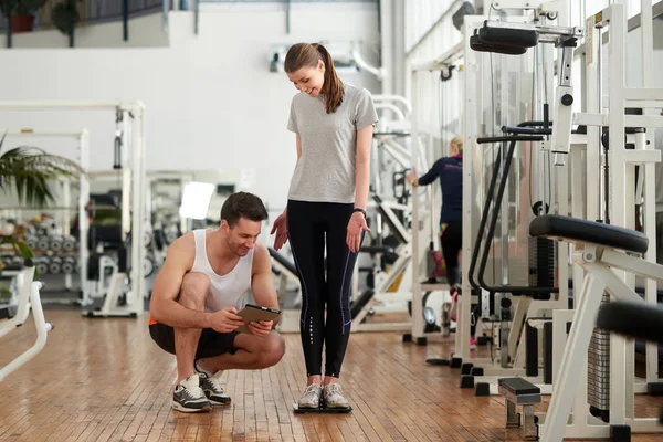 Mujer feliz sonriendo en básculas de pesaje en el gimnasio . — Foto de Stock