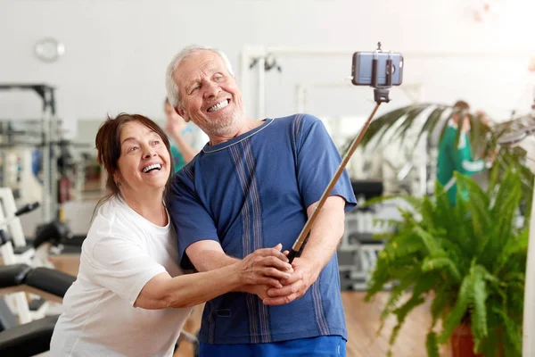 체육관에서 셀카를 찍는 미소 짓는 노인 부부. — 스톡 사진