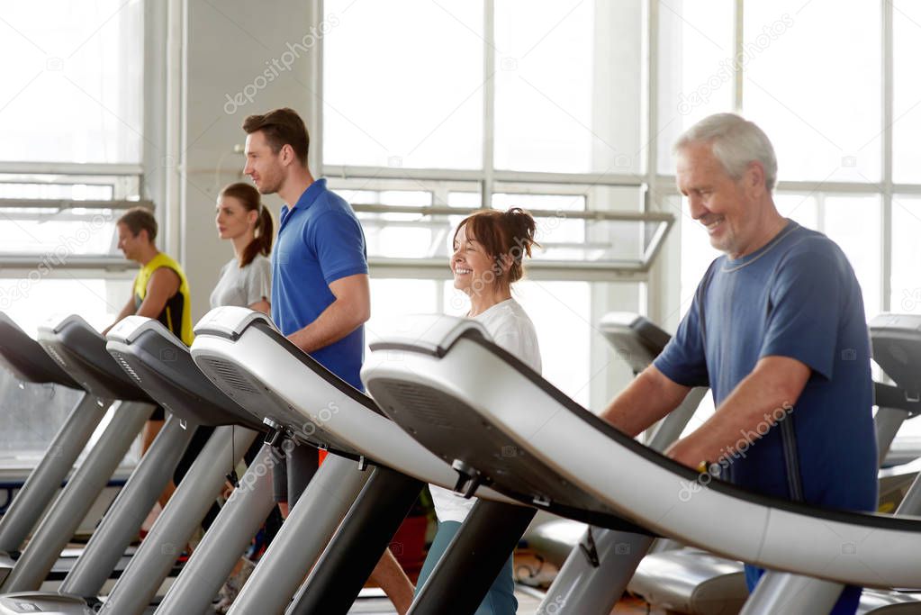 People working out on a treadmill running track.