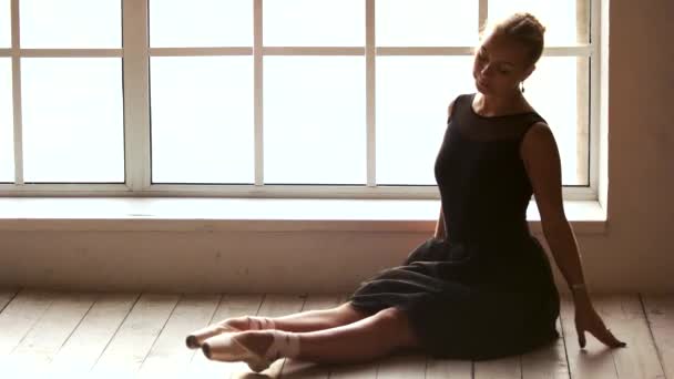 Gyönyörű nő ül a padlón a balett osztályban. — Stock videók