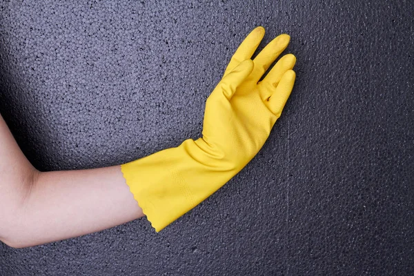 Vrouwelijke hand in gele rubber handschoen. — Stockfoto