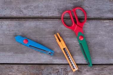 Ahşap arka planda makas ve sabit bıçaklar.