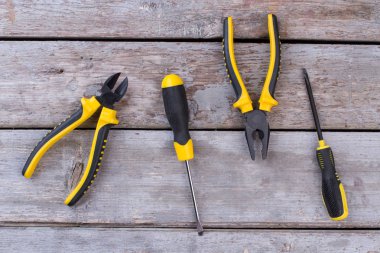 Ahşap arka planda pense ve tornavida var..