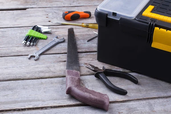 Tool box and various construction instruments on wooden surface.