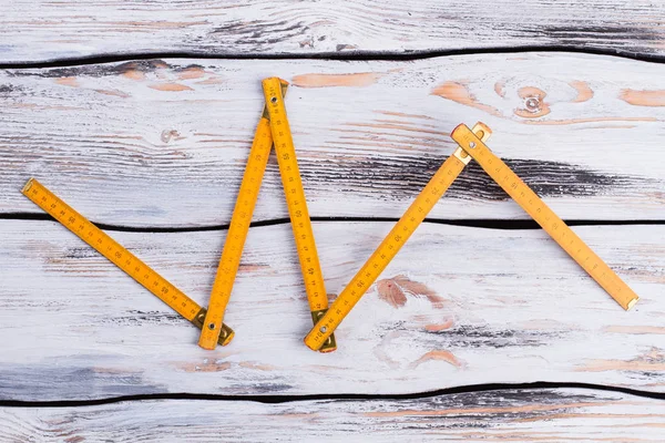 Yellow folding ruler on wooden background. — 스톡 사진