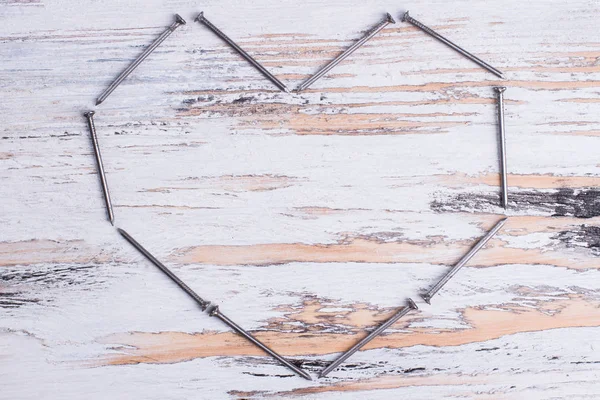 Herz aus Nägeln auf Holzgrund. — Stockfoto