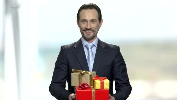 Hombre de negocios sonriente sosteniendo cajas de regalo . — Vídeos de Stock