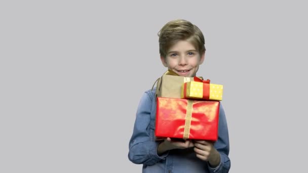 Lindo niño sonriente sosteniendo cajas de regalo. — Vídeos de Stock