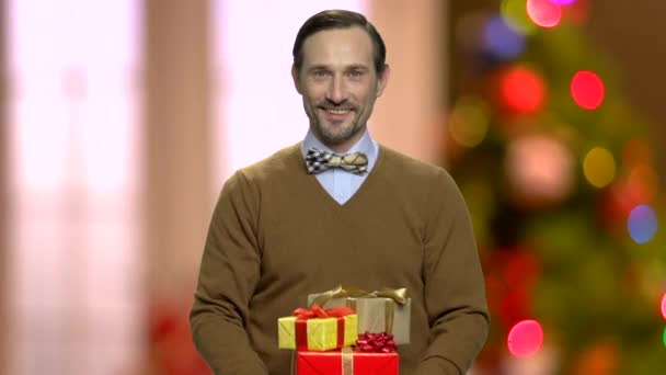 Pohledný muž poskytující vánoční dárky. — Stock video